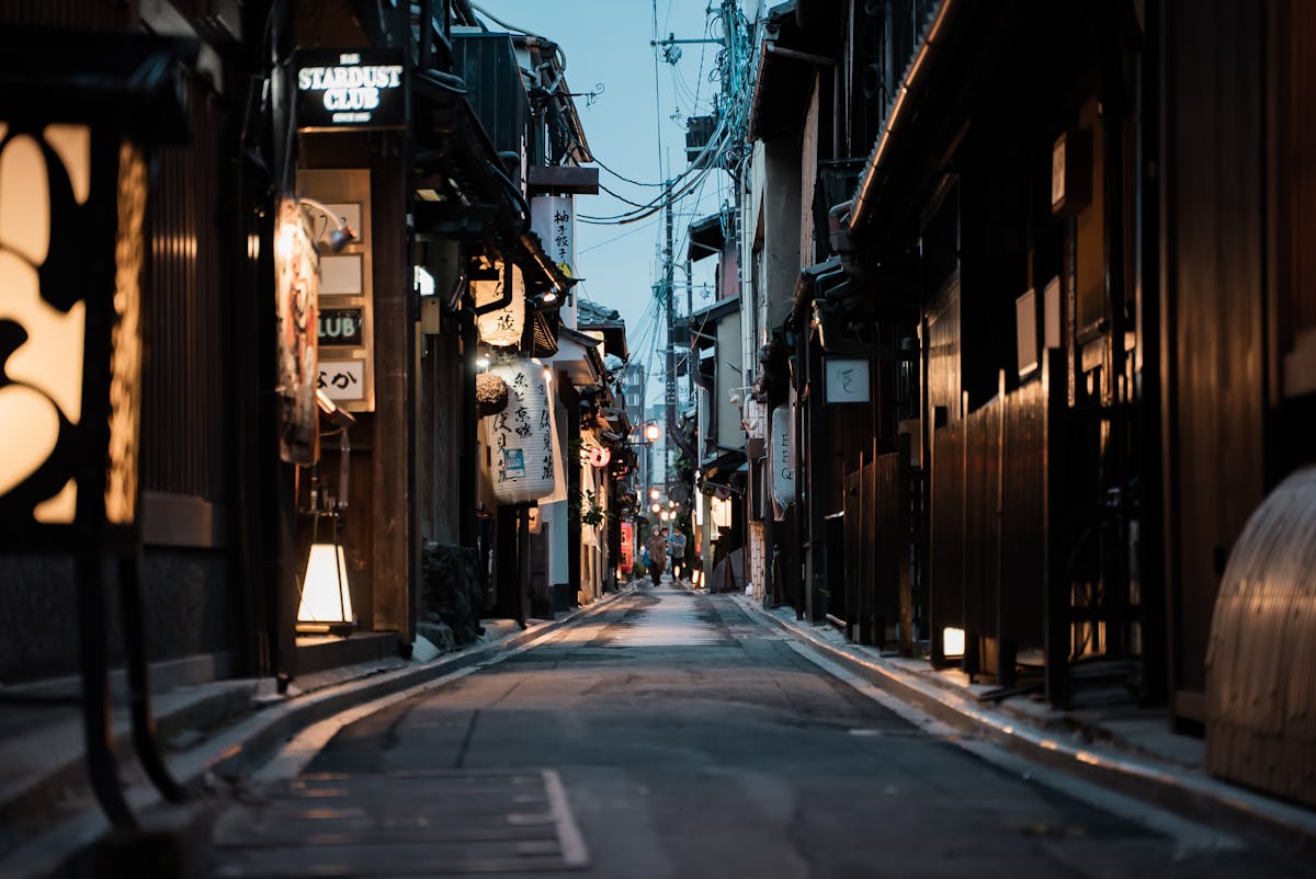 Narrow Kyoto street with lanterns at dusk