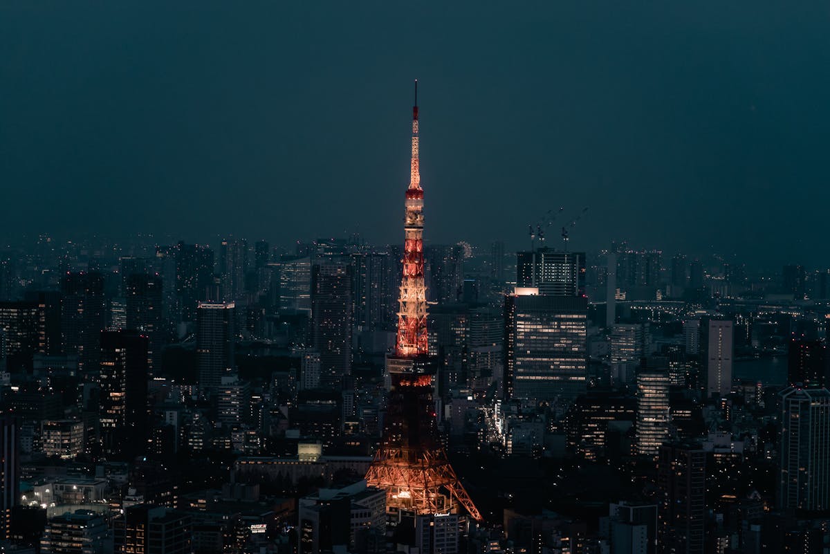 Tokyo Tower lit up at night surrounded by the city skyline