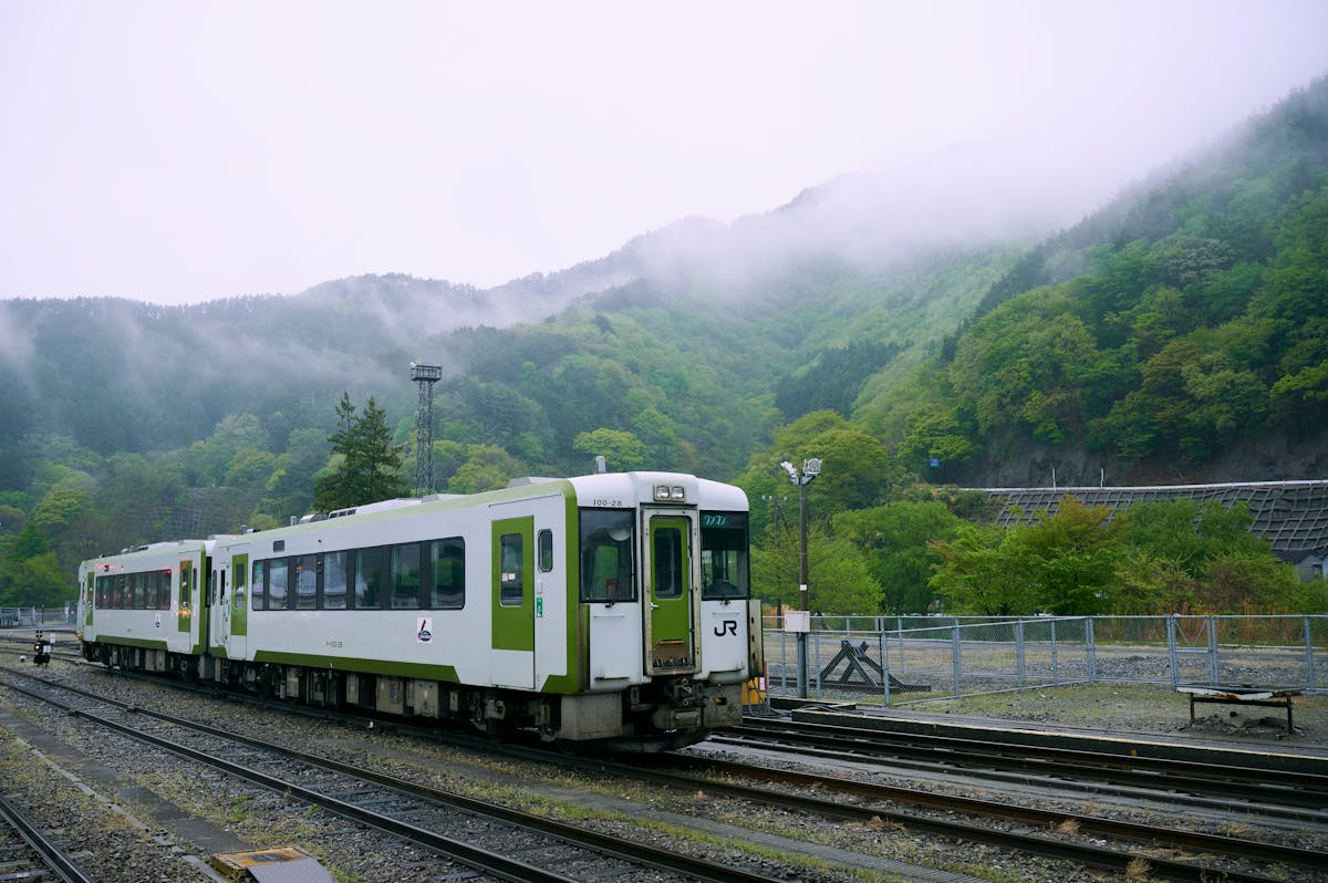 Train in Japan with misty green mountains
