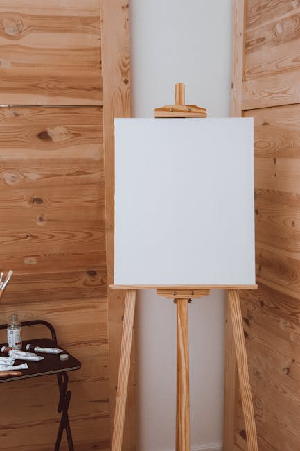 Artist easel with canvas and paints in studio