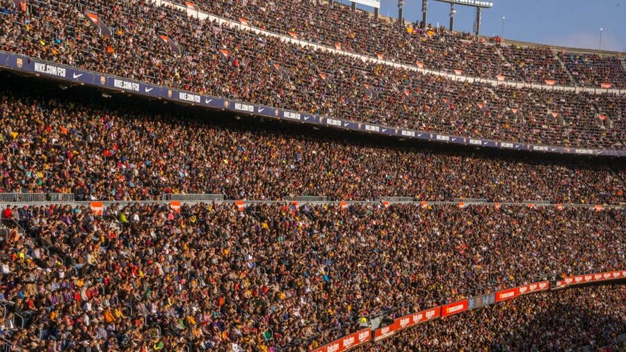 Excited football fans watching a match in a packed stadium