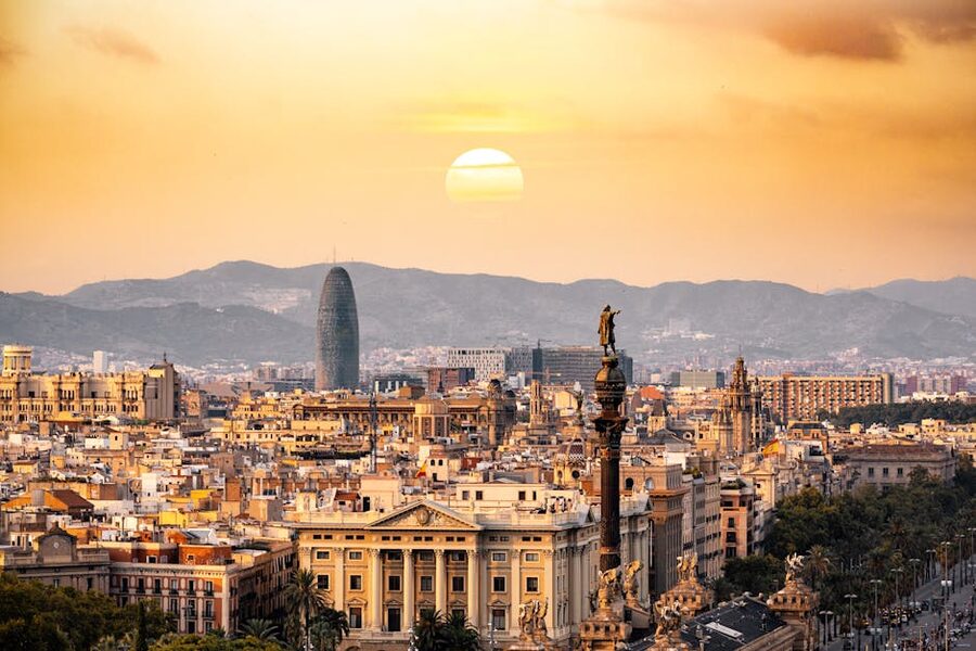 Barcelona skyline at sunset with city lights and mountains