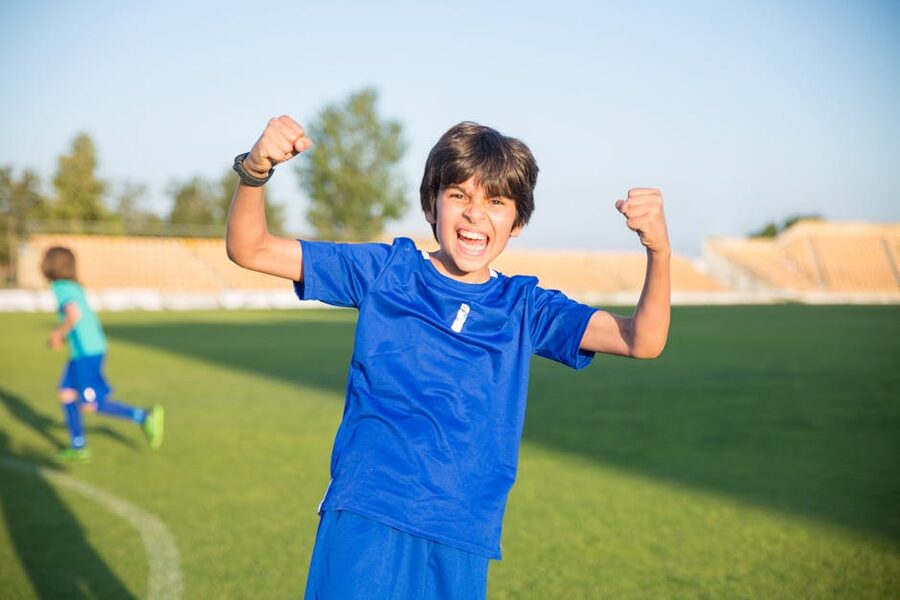 Excited boy wearing football jersey at a stadium