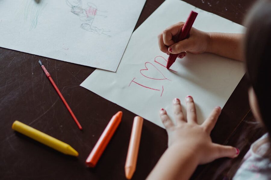 Child creating artwork with crayons
