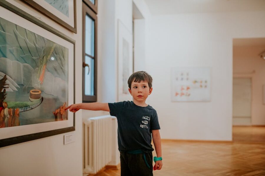 Children pointing at paintings in an art gallery