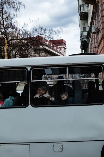 Children looking out of a bus window watching the city go by