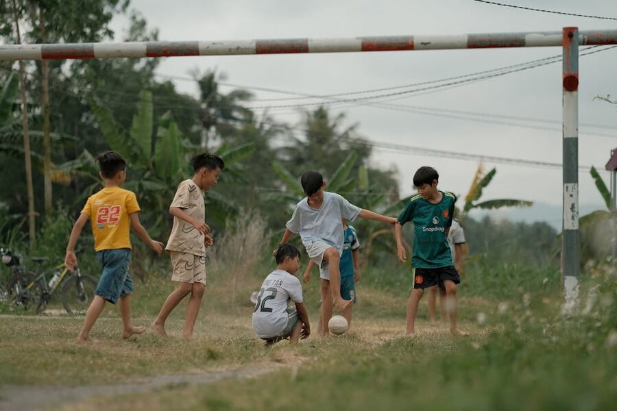Children kicking a football on an outdoor pitch