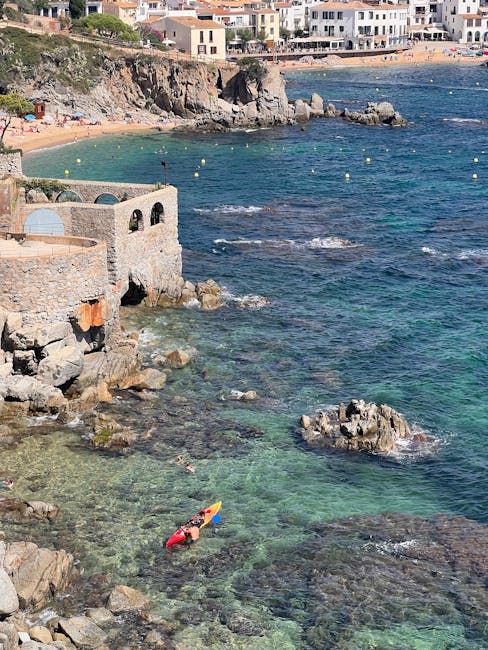 Kayakers paddling through turquoise sea along Costa Brava coast