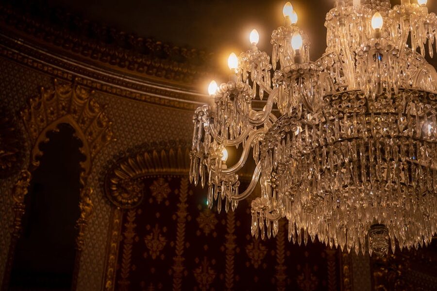 Enormous crystal chandelier hanging in an ornate palace ballroom