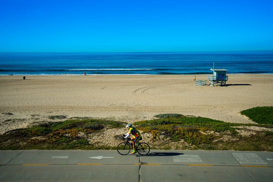 Cyclists riding along a sunny coastal beach path