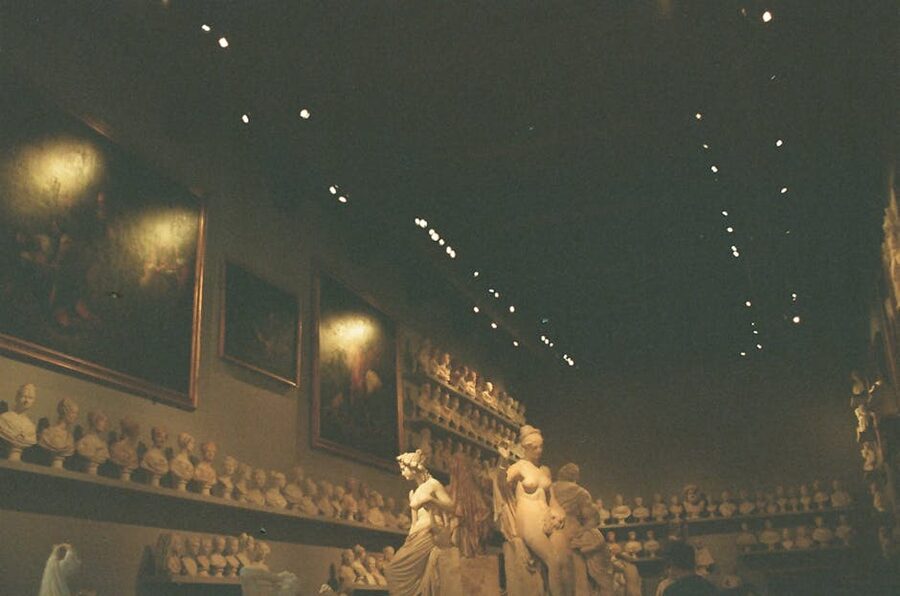 Dimly lit museum gallery with sculptures