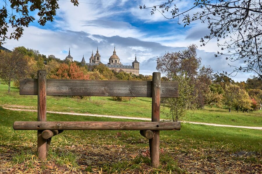 Wooden bench on grass field near El Escorial monastery