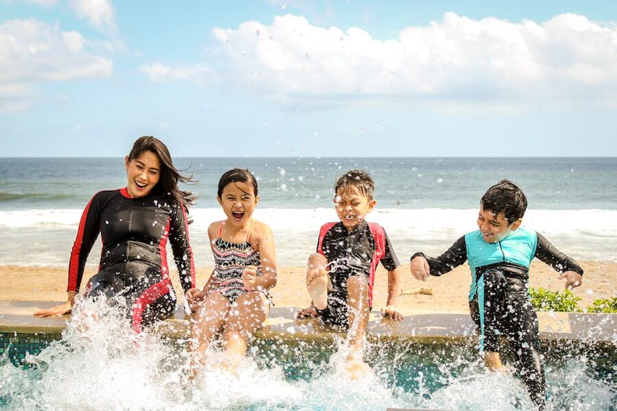 Family enjoying a beach day with children swimming at the coast