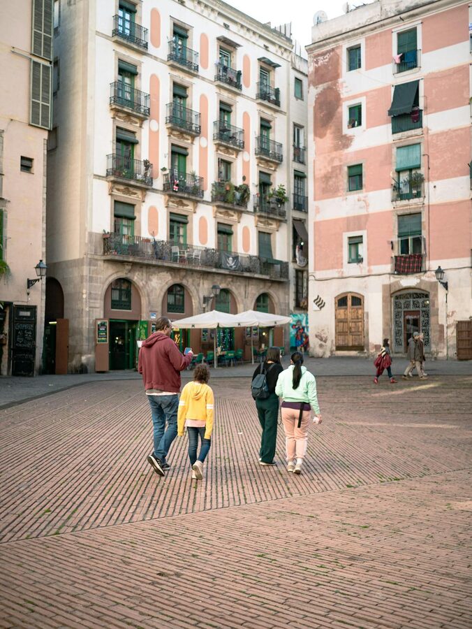 Family walking through a historic square in Barcelona old town