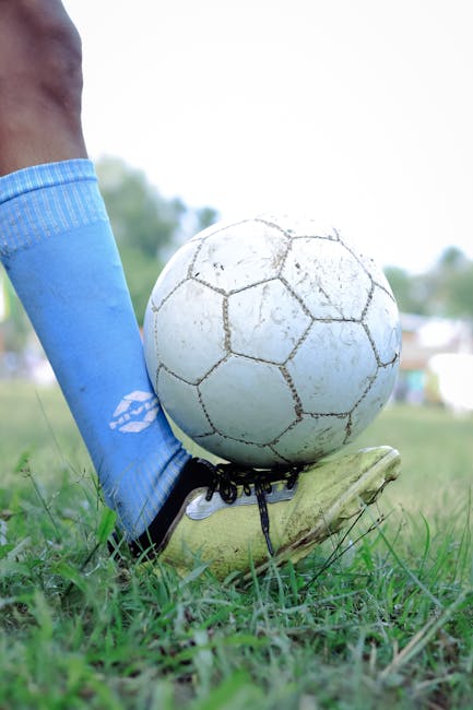 Close-up of football boots on grass pitch