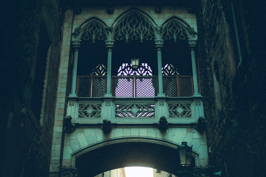 Ornate Gothic stone bridge connecting buildings overhead