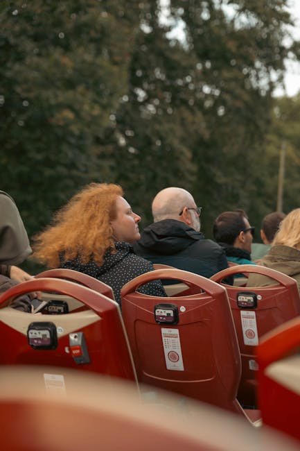 Red open-top sightseeing bus on a city street tour