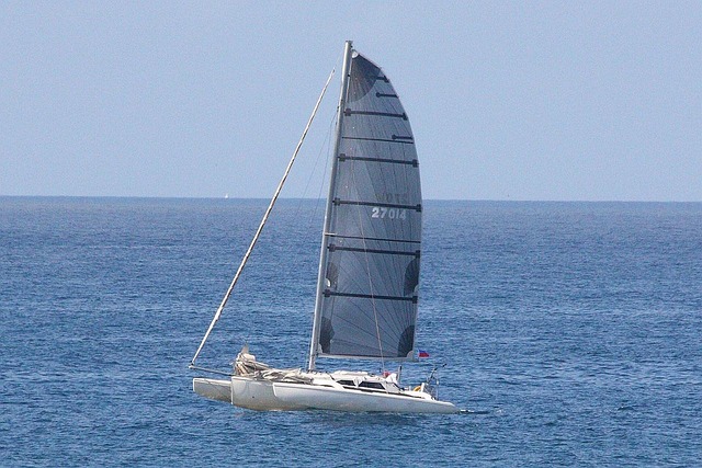 White catamaran sailboat cruising on open ocean
