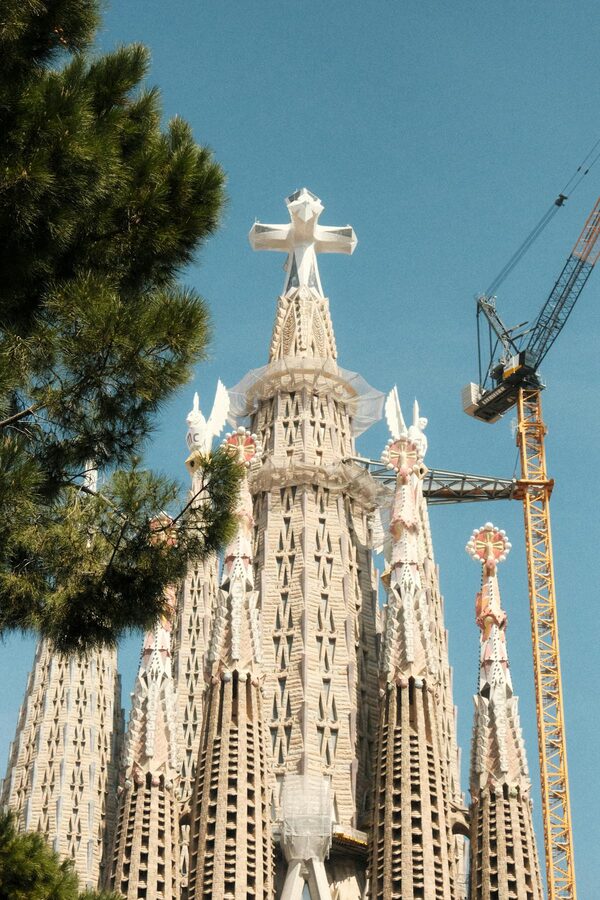 Sagrada Familia towers with construction crane against blue sky