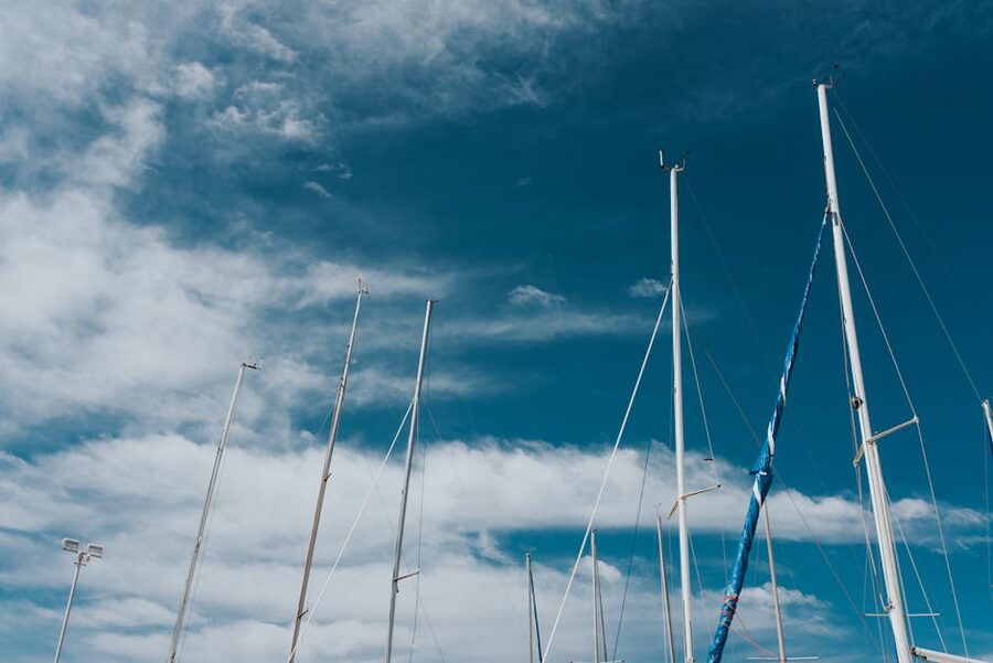 View up sailboat mast against blue sky